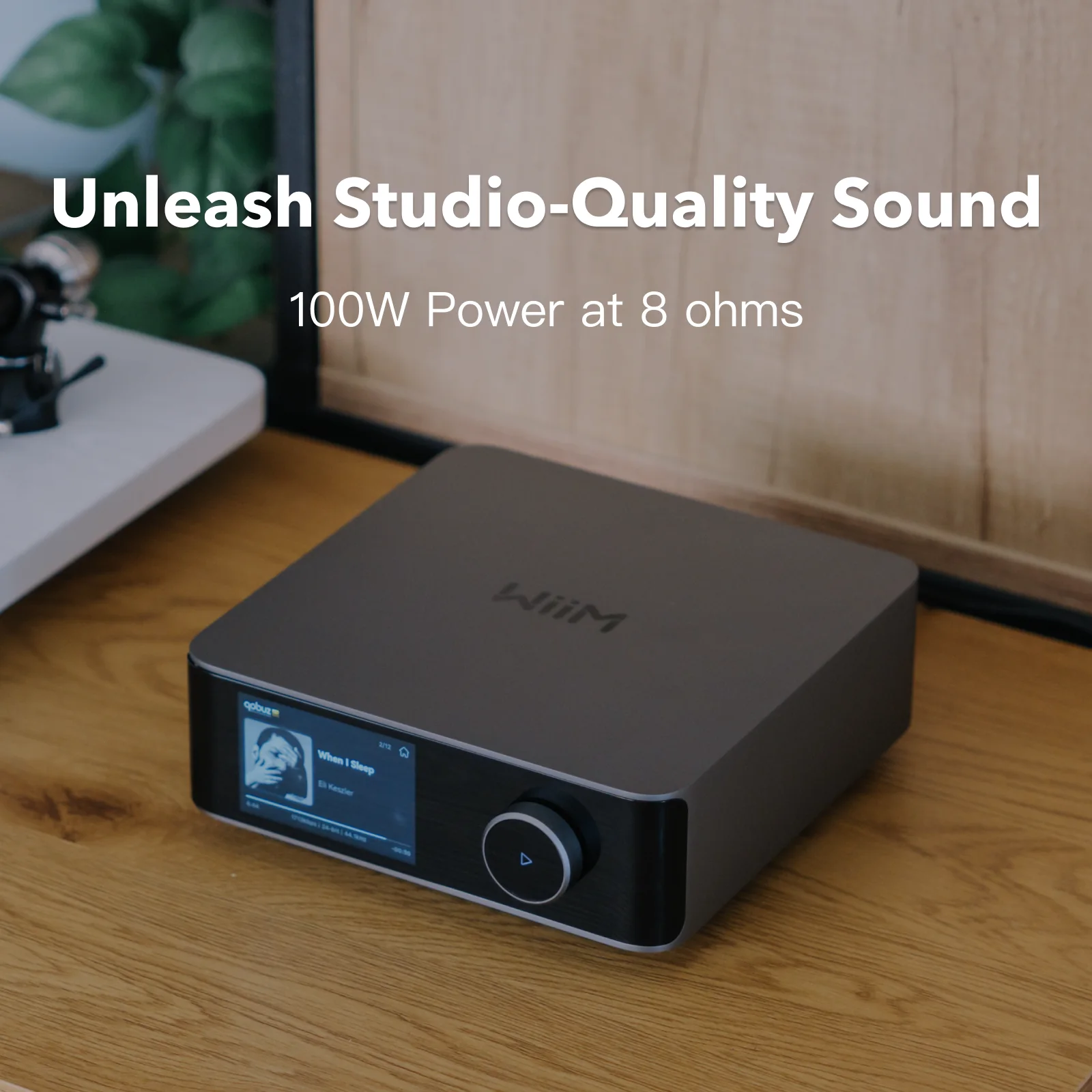 WiiM Amp Ultra posé sur un meuble en bois, écran allumé