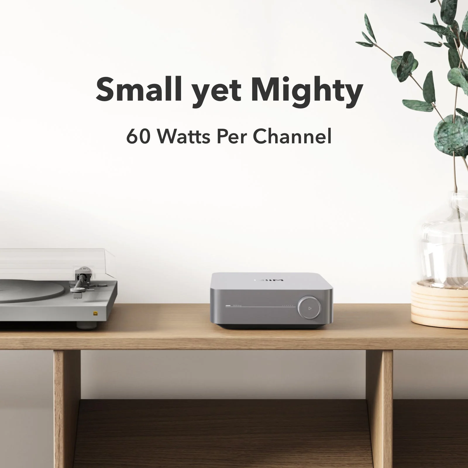 WiiM Amp posé sur un meuble en bois à côté d'une platine vinyle